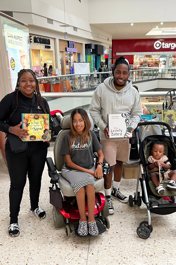Family of two with child in a shopping mall, one child in a stroller. With award winning author